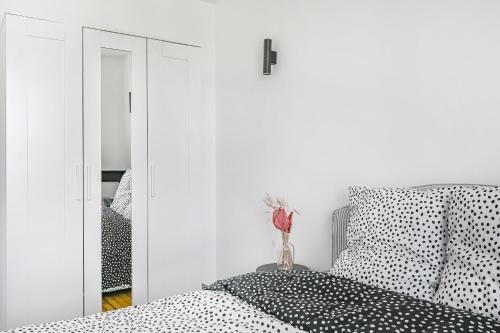 a white bedroom with a bed and a mirror at Sublime appart La Défense Paris Gare 2Pers in Nanterre