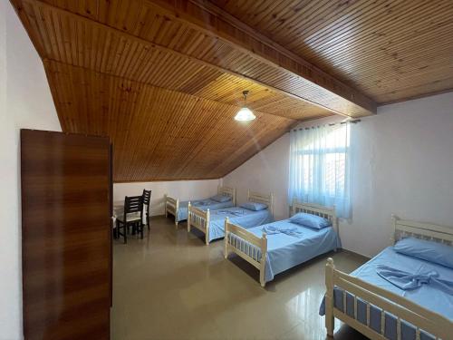 Habitación con 3 camas, mesa y sillas en My Hostel - Privates and Dorms, en Shkodër
