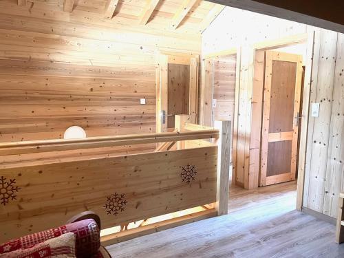 un sauna avec des murs en bois et une personne assise dans une pièce dans l'établissement Chalet le Lynx quiet vacation, à Xonrupt-Longemer