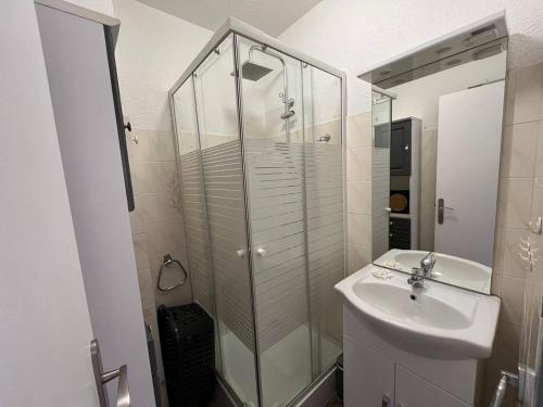 une salle de bain avec une douche en verre et un lavabo dans l'établissement Appartement Beau Rivage Narbonne Plage, à Narbonne-Plage