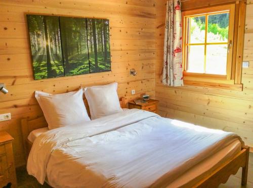 une chambre avec un lit dans une cabane en rondins dans l'établissement Chalet le Lynx quiet vacation, à Xonrupt-Longemer