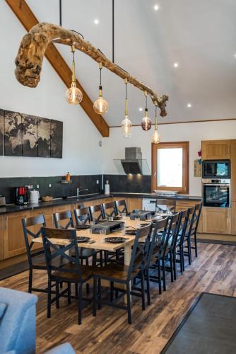 une salle à manger avec une longue table et des chaises dans l'établissement 220m apartment with terrace for 14 people, à Saint-Jean-de-Maurienne