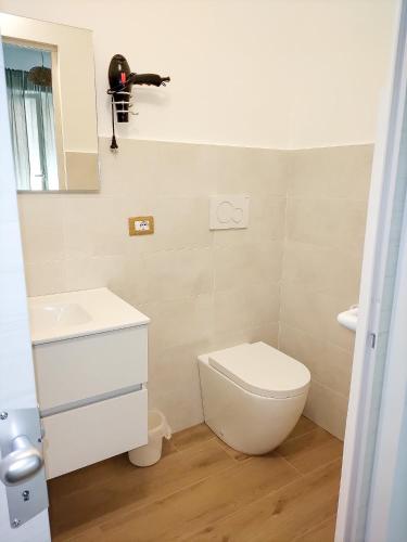 a bathroom with a toilet and a sink and a mirror at CasaBlanc in Santa Teresa di Riva