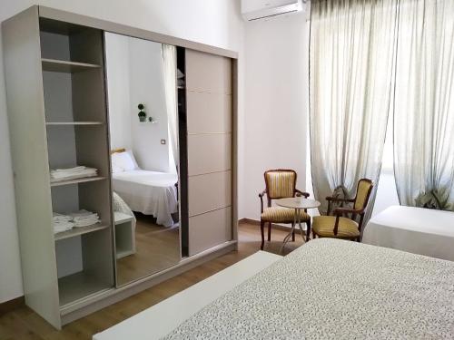 a bedroom with a mirror and a bed and a chair at CasaBlanc in Santa Teresa di Riva