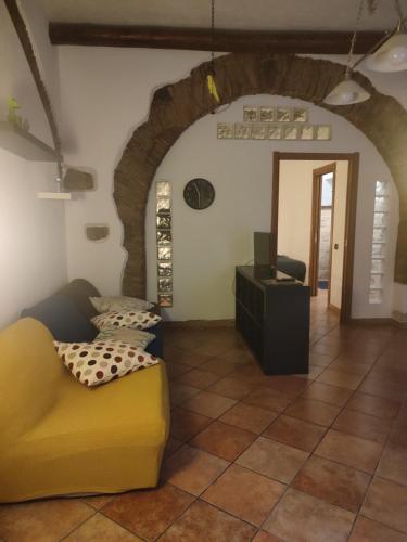 a living room with a yellow couch and a table at Casa Traiano in Benevento