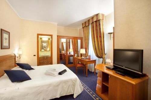 a hotel room with a bed and a flat screen tv at Hotel Cappello D'Oro, BW Signature Collection in Bergamo