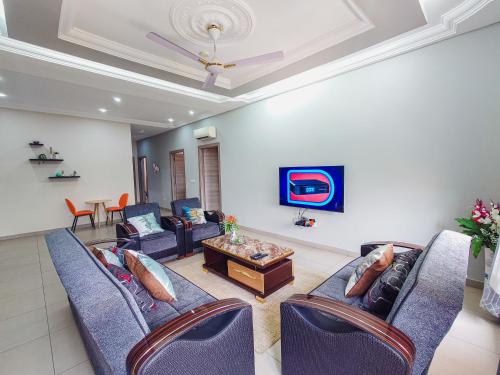 a living room with couches and a table at Queens View Apartment in Accra