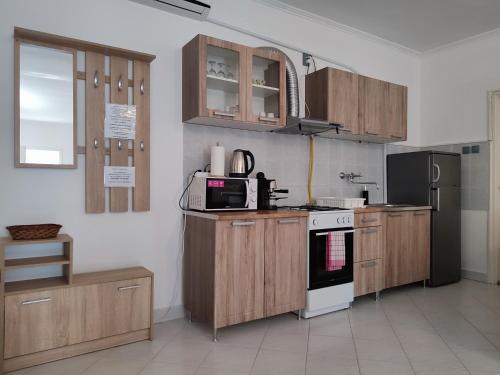 a kitchen with wooden cabinets and a stove top oven at Estike Apartmanok in Tiszafüred