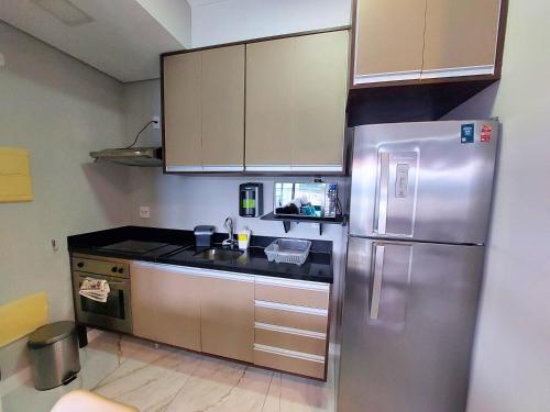 a kitchen with a stainless steel refrigerator and cabinets at Book Santos - Unlimited 2611 - Studio conceito com Vista Mar in Santos