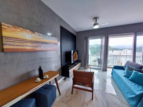 a living room with a blue couch and a table at Book Santos - Unlimited 2611 - Studio conceito com Vista Mar in Santos