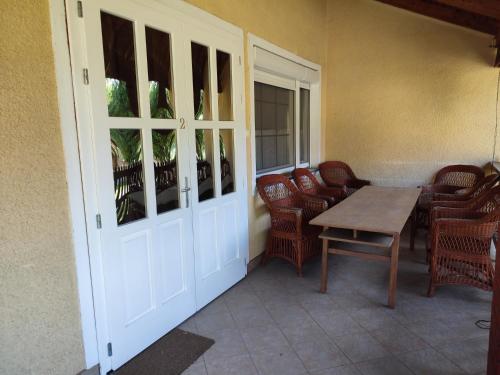 a room with a table and chairs and a door at Estike Apartmanok in Tiszafüred