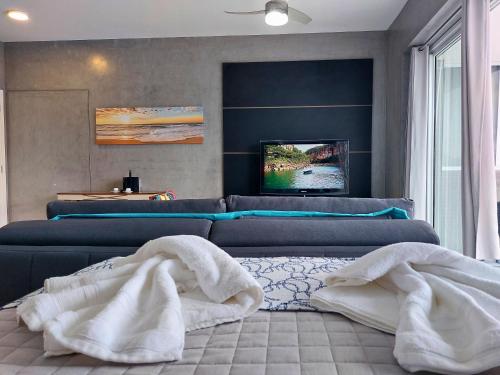 a living room with a couch and towels on the floor at Book Santos - Unlimited 2611 - Studio conceito com Vista Mar in Santos