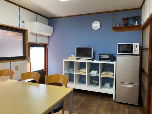 a room with a kitchen with a refrigerator and a table at Naoshima Haru House in Naoshima