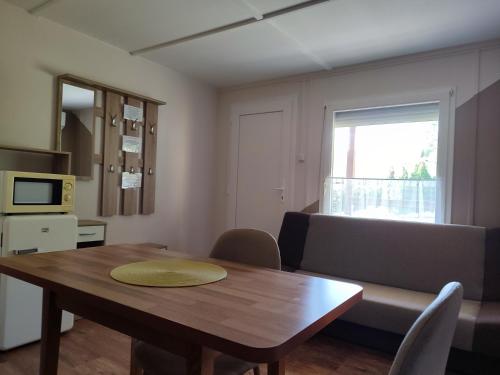 a living room with a wooden table and a couch at Estike Apartmanok in Tiszafüred