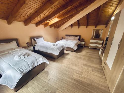a bedroom with two beds and a television in it at Bujtina Bashllari in Zvarisht