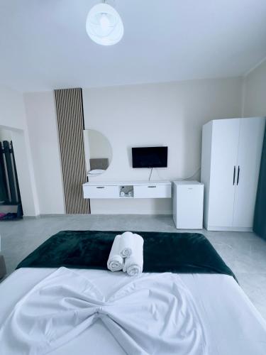 a white bed with a towel on top of it at Molla Hotel Restorant in Shëngjin
