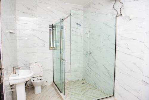 a bathroom with a glass shower and a toilet at BCL Homes and Apartments in Rubuchi