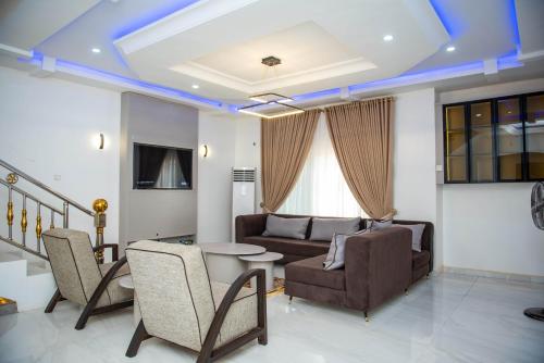 a living room with a couch and a table and chairs at BCL Homes and Apartments in Rubuchi