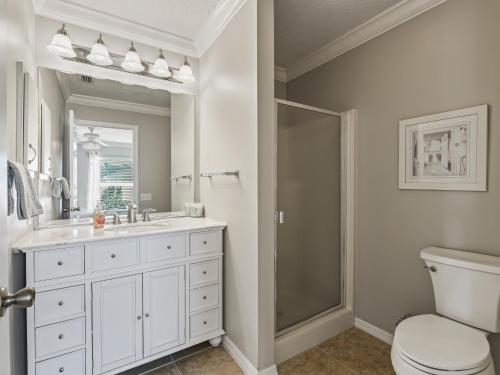 a bathroom with a toilet and a sink and a mirror at 1315 Z2B VILLAGE OF RIO GRANDE by REMAX Premier in The Villages