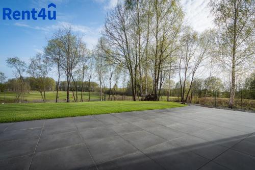 un aparcamiento vacío con árboles en un parque en Fairway House by Rent4You, en Naterki