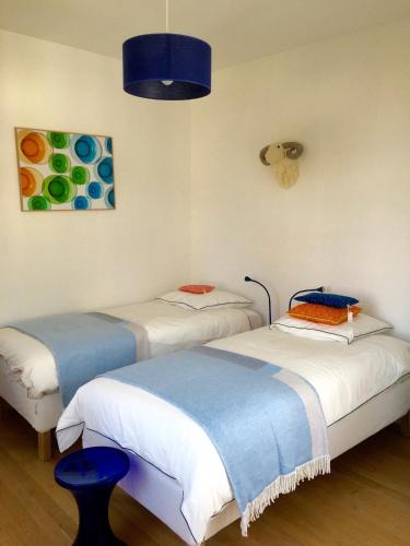 une chambre avec deux lits et un tableau au mur dans l'établissement Petite maison de charme - Paris - Rolland Garros - Versailles - Golf - Normandie, à Garches