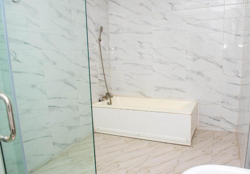a bathroom with a toilet and a glass shower at BCL Homes and Apartments in Rubuchi