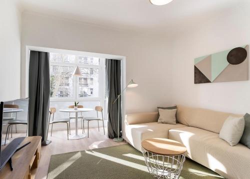 a living room with a couch and a table at Estoril One - New apartment in Estoril