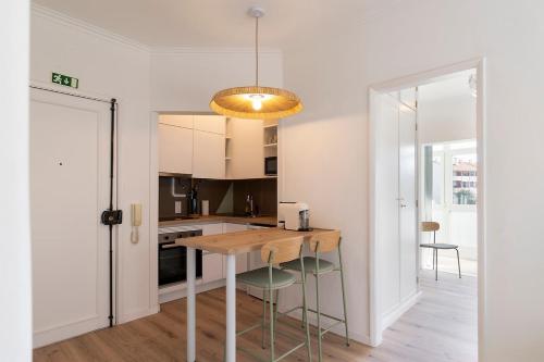a kitchen with a wooden table and chairs at Estoril One - New apartment in Estoril