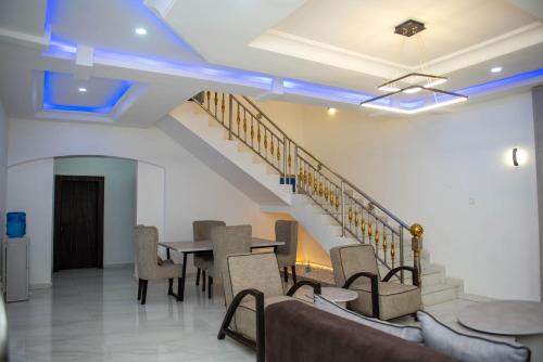 a room with a table and chairs and stairs at BCL Homes and Apartments in Rubuchi