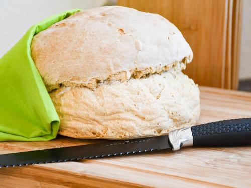 a loaf of bread on a cutting board with a knife at Ferienhaus Wendelinus mit Pool & Sauna in Hausach