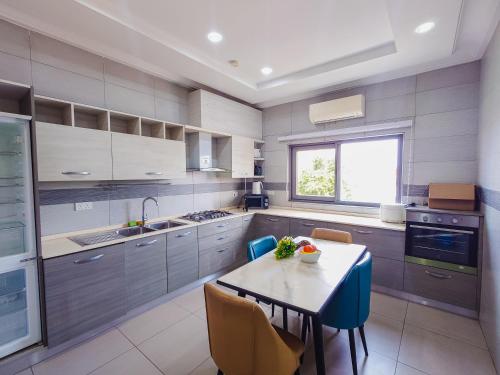 a kitchen with a table and some chairs and a table and a counter at Queens View Apartment in Accra