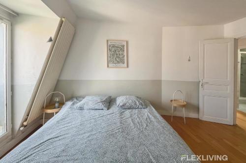 une chambre avec un lit et deux chaises dans l'établissement Lovely 2 bedrooms - Paris - rue de Prague - Flexliving, à Paris