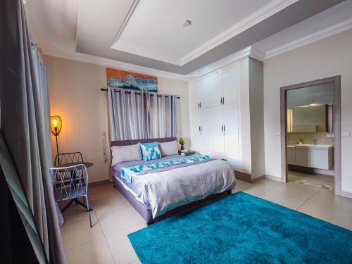 a bedroom with a large bed and a blue rug at Queens View Apartment in Accra