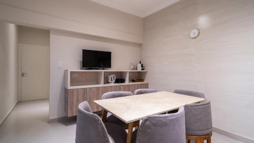 a dining room with a table and chairs and a tv at Departamento de lujo en centro de casco histórico in San Miguel de Tucumán