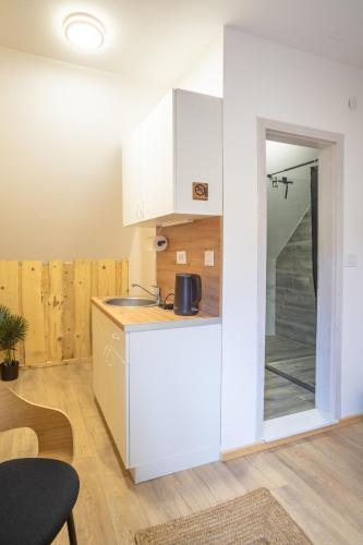 a kitchen with white cabinets and a table at Sunny Village - Wild Goat apartments in Žabljak