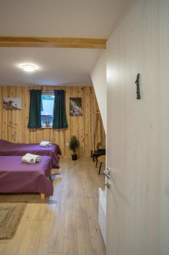 two beds in a room with wooden walls at Sunny Village - Wild Goat apartments in Žabljak
