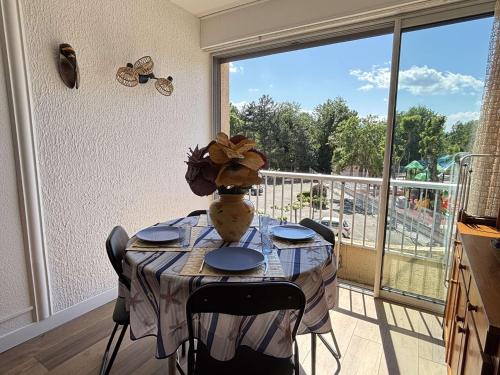 une table avec un vase au-dessus d'un balcon dans l'établissement Appartement 2 pièces cabine 4 couchages ARGELES SUR MER AR460-130, à Argelès-sur-Mer