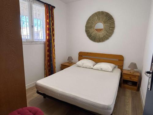 une chambre avec un lit et un miroir au mur dans l'établissement Appartement 2 pièces cabine 4 couchages ARGELES SUR MER AR460-130, à Argelès-sur-Mer