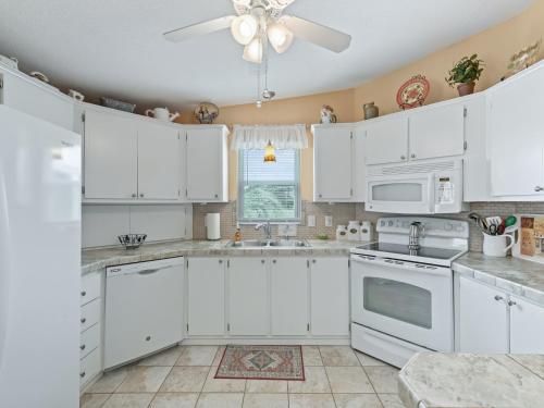 a kitchen with white cabinets and a ceiling fan at 1640 Z1 VILLAGE OF COUNTRY CLUB HILLS by REMAX Premier in The Villages