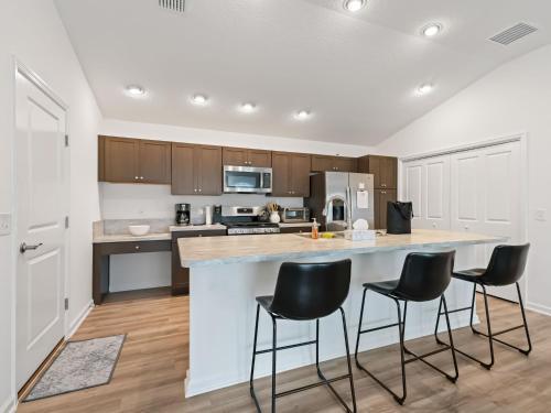 a kitchen with a large island with black bar stools at 1642 Z5 VILLAGE OF LAKE DENHAM by REMAX Premier in Leesburg