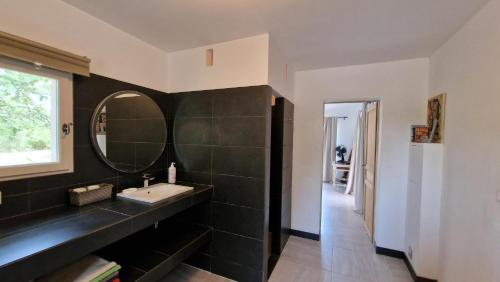 une salle de bain avec un lavabo et un miroir dans l'établissement villa la Lanterne, au Plan-de-la-Tour