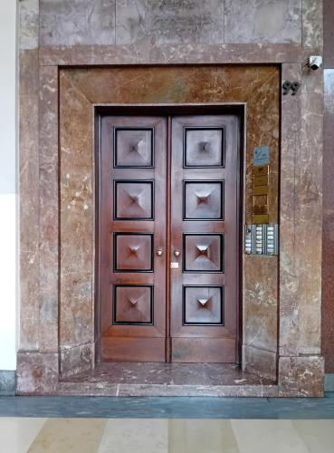 a large wooden door in a building with at Piazza Castello 200 sqm - Terrace - Jacuzzi in Turin