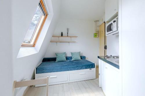 une petite pièce avec un lit et une fenêtre dans l'établissement Petit studio 16ème arrondissement - Boulogne, à Paris