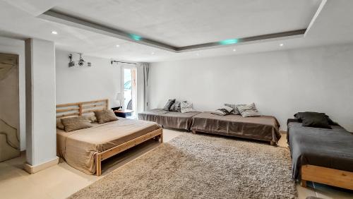 - une chambre avec 2 lits, un canapé et un tapis dans l'établissement villa la Lanterne, au Plan-de-la-Tour