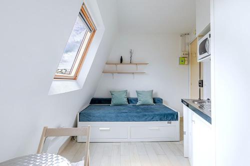 une petite pièce avec un lit et une fenêtre dans l'établissement Petit studio 16ème arrondissement - Boulogne, à Paris