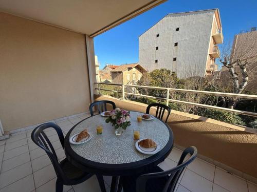 une table avec des assiettes de nourriture sur un balcon dans l'établissement Mass, à Valras-Plage