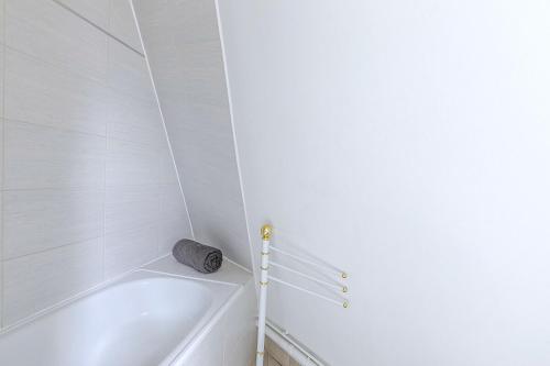 La salle de bains blanche est pourvue d'une baignoire blanche. dans l'établissement Petit studio 16ème arrondissement - Boulogne, à Paris