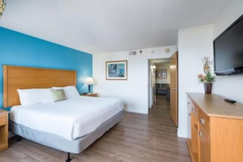 une chambre d'hôtel avec un lit et une télévision à écran plat dans l'établissement The Ocean Key Resort, à Virginia Beach