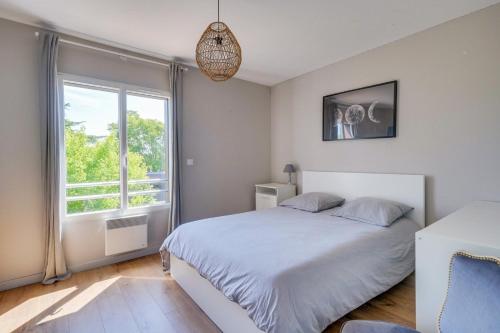 une chambre avec un lit blanc et une fenêtre dans l'établissement Beautiful house in Le Bouscat with pool & parking, à Le Bouscat