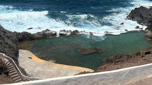 a swimming pool on the side of the ocean at Ocean breeze retreat in Gáldar